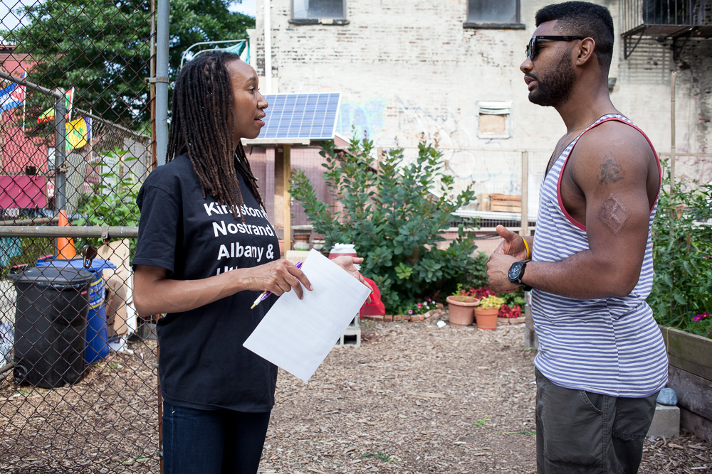 A CBFC volunteer with a clipboard surveys a resident in a community garden in Central Brooklyn, summer 2014.